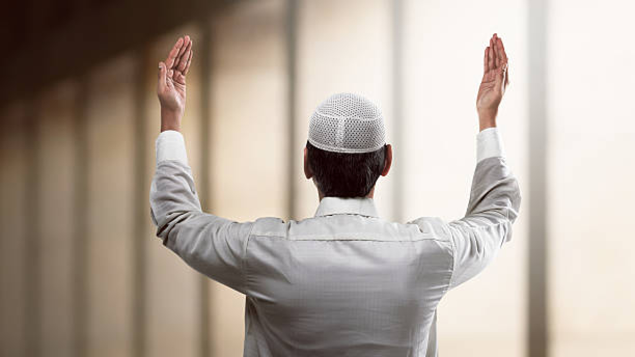 Back view of young muslim man praying